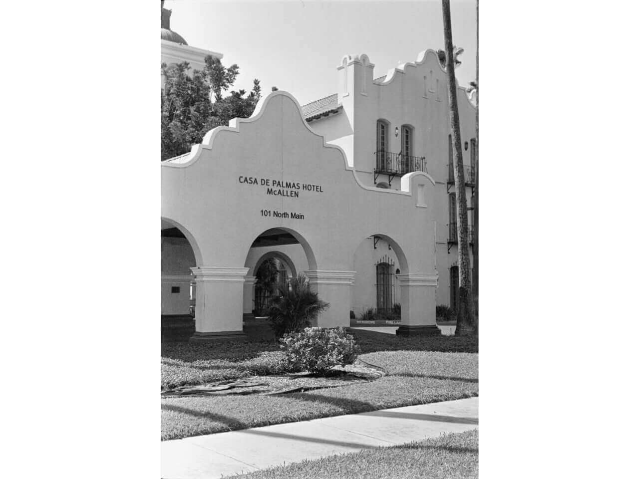 Historic Casa de Palmas Hotel in black and white, featuring a distinctive architectural style and lush front garden.