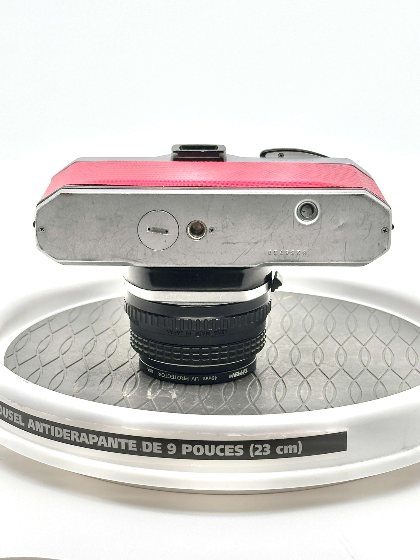 Top view of Japanese Asahi Pentax K1000 Red 35mm film camera with 50mm f1.7 lens on a textured surface.
