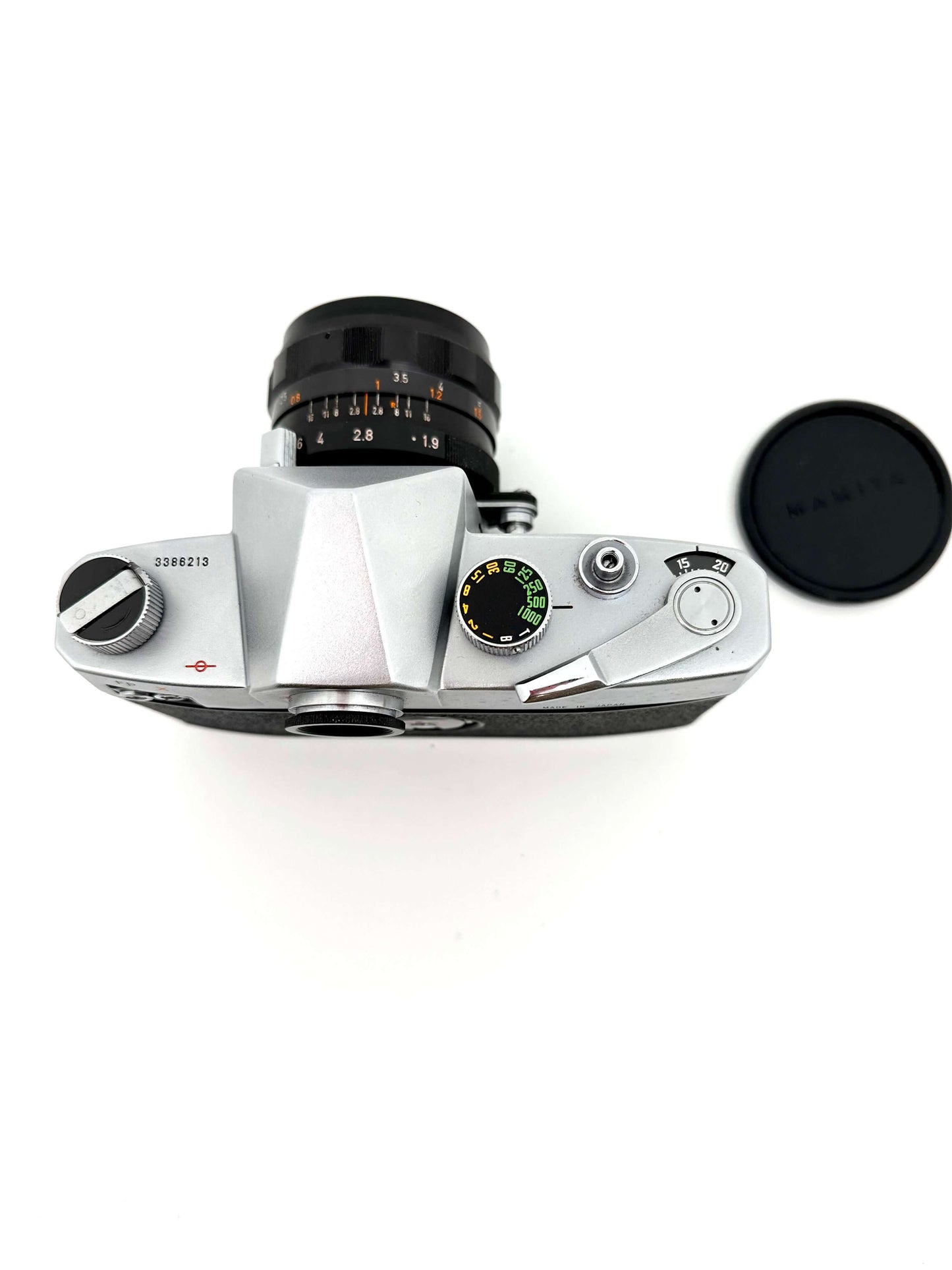 Top view of Mamiya Prismat NP 35mm vintage film camera with Canon 50mm f1.9 lens and lens cap.