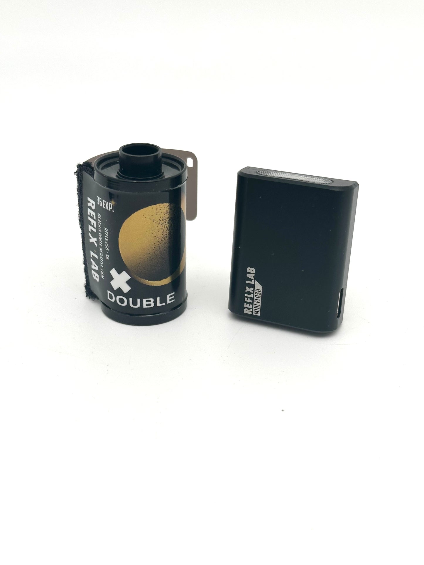 Reflx Lab Mini Flash V2 Standing Upright Next to 35mm roll for size comparison