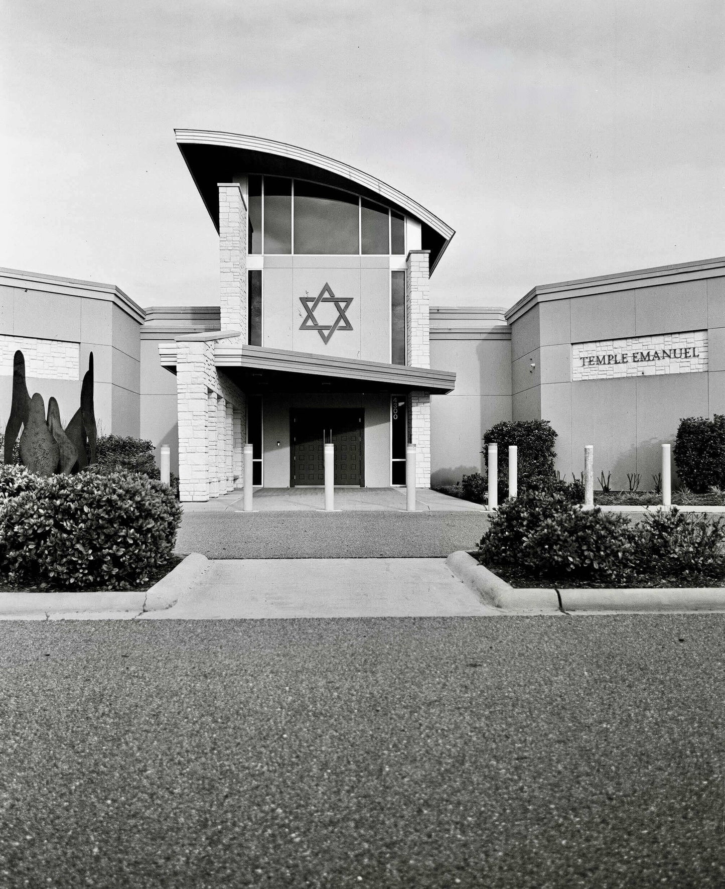 Exterior view of Temple Emanuel featuring a Star of David symbol and modern architectural design.