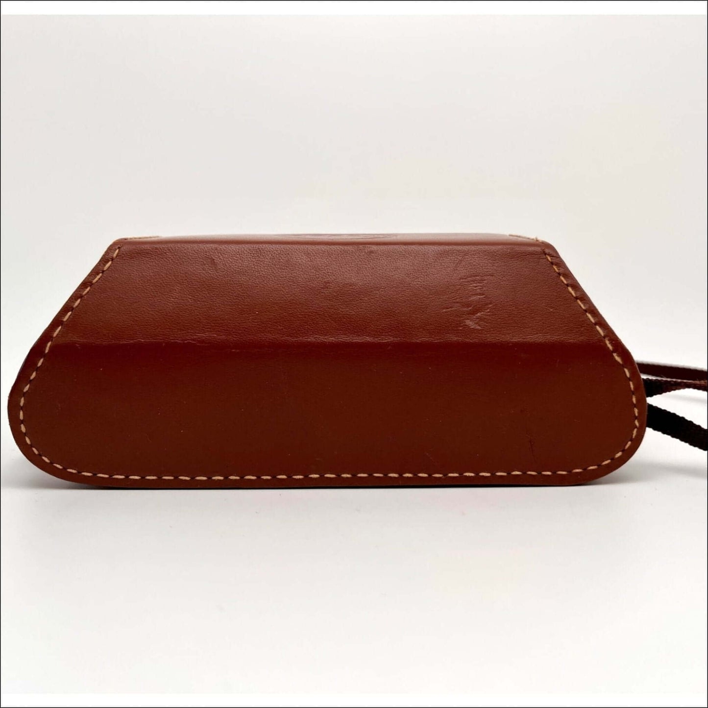 Bottom view of a vintage Kodak camera case, showing leather texture and stitching details.