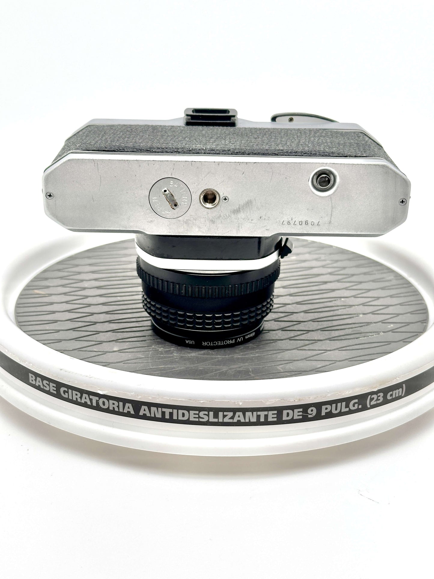 Top view of Japanese Asahi Pentax K1000 black 35mm film camera on a rotating display stand.