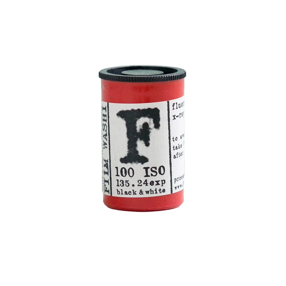 A red cylindrical canister of Film Washi black and white photographic developer, featuring a white label with a large black letter 'F' and technical specifications, set against a solid light blue background.