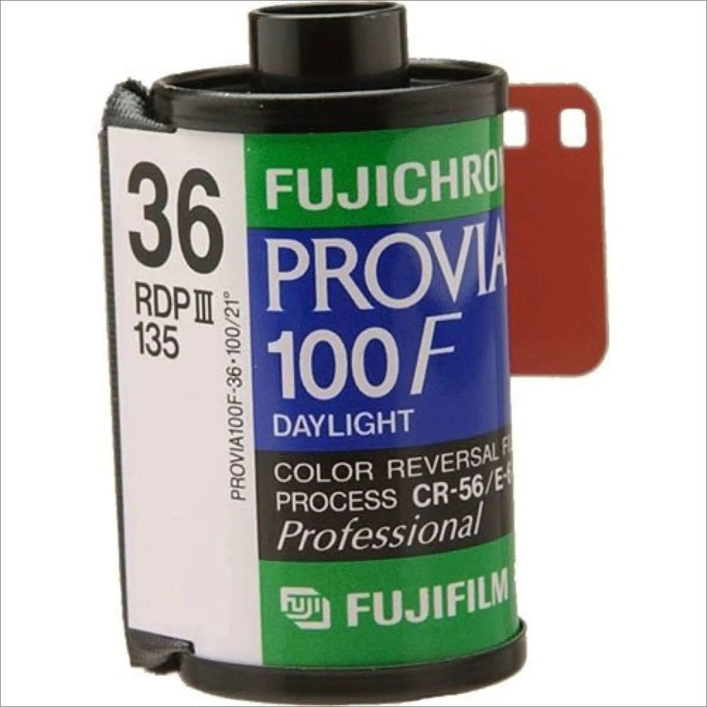 Fujichrome provia 100f daylight color reversal film canister in green, blue, and white with black plastic cap.