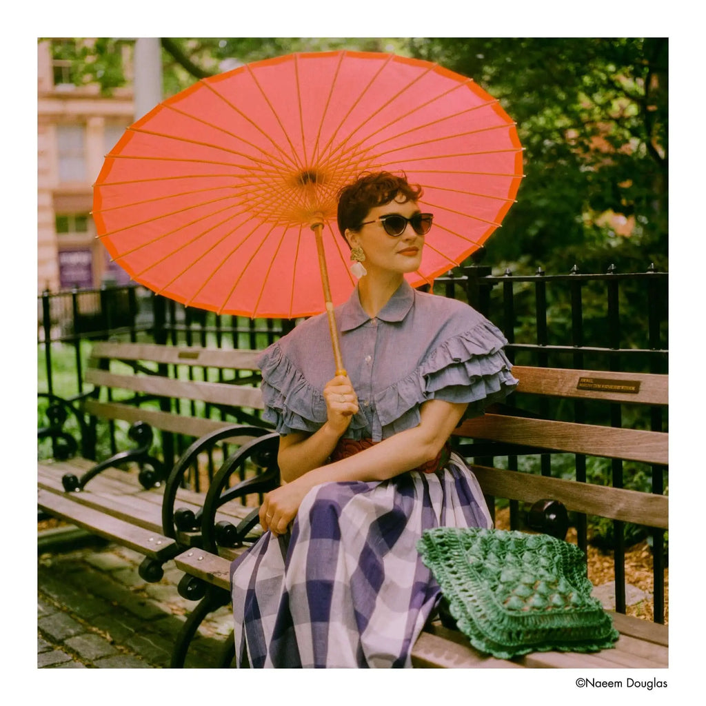 Vibrant orange paper parasol with wooden ribs