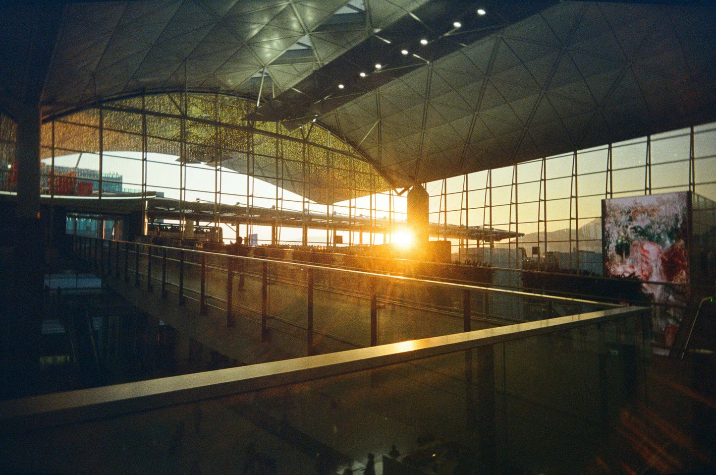 Sunset illuminating the modern architecture of an airport terminal's interior space.