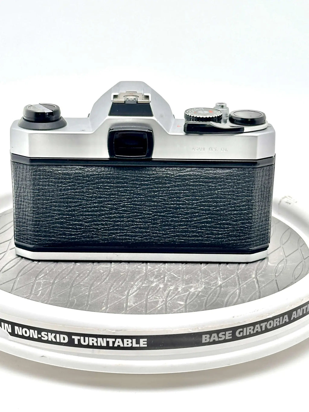 Silver-bodied canon ae-1 film camera with a textured black leather grip.