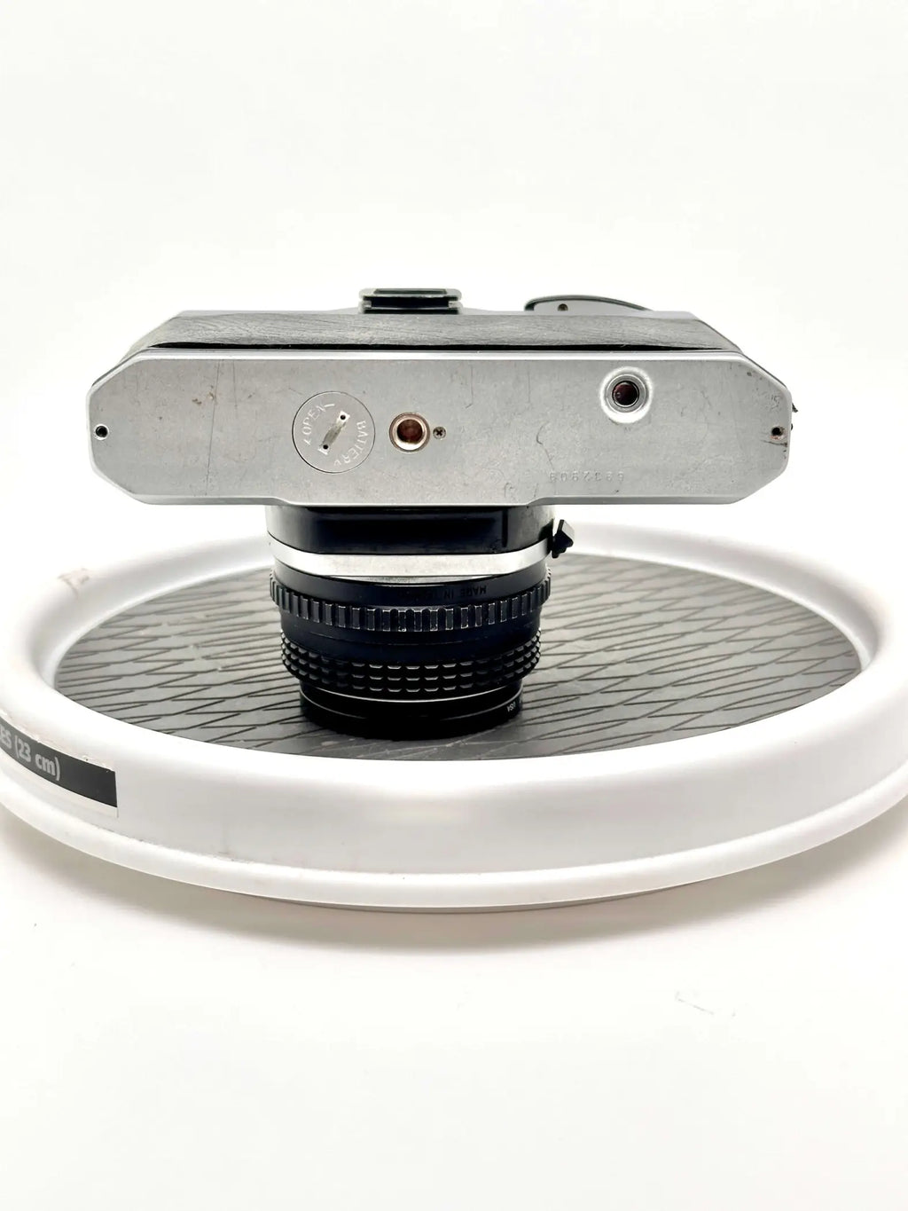 Silver-bodied nikon fm2 film camera with a black lens mounted on top.