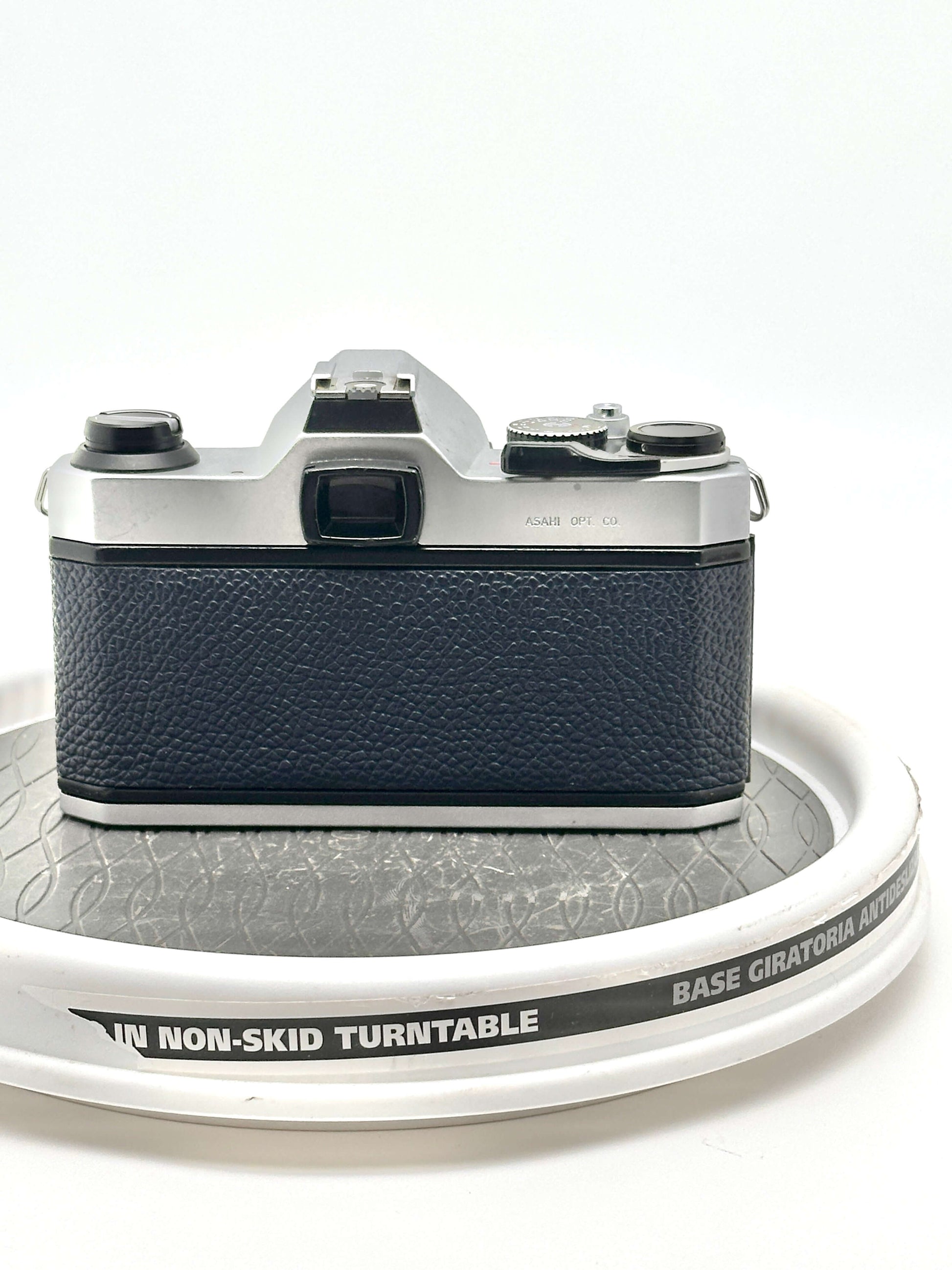 Back view of a Japanese Asahi Pentax K1000 blue 35mm film camera on a non-skid turntable.