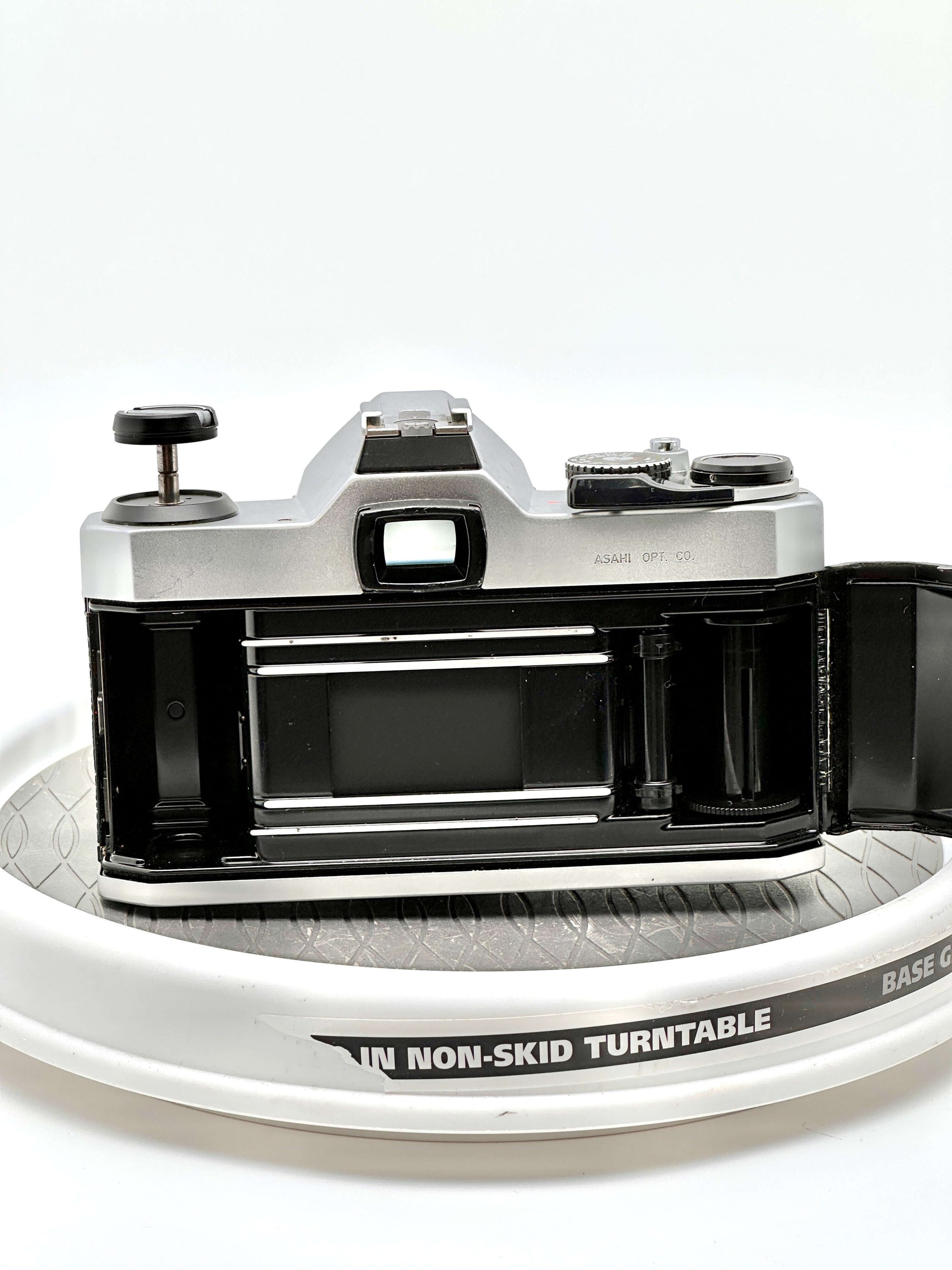 Pentax K1000 film camera rear view showing film compartment and controls on a turntable.
