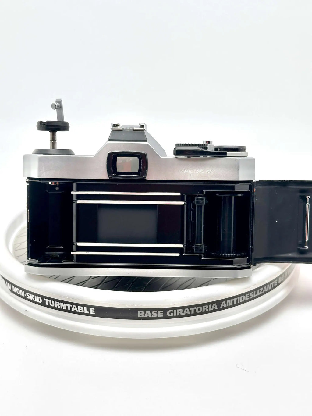 Silver-bodied canon ae-1 film camera with black accents and a visible shutter mechanism.