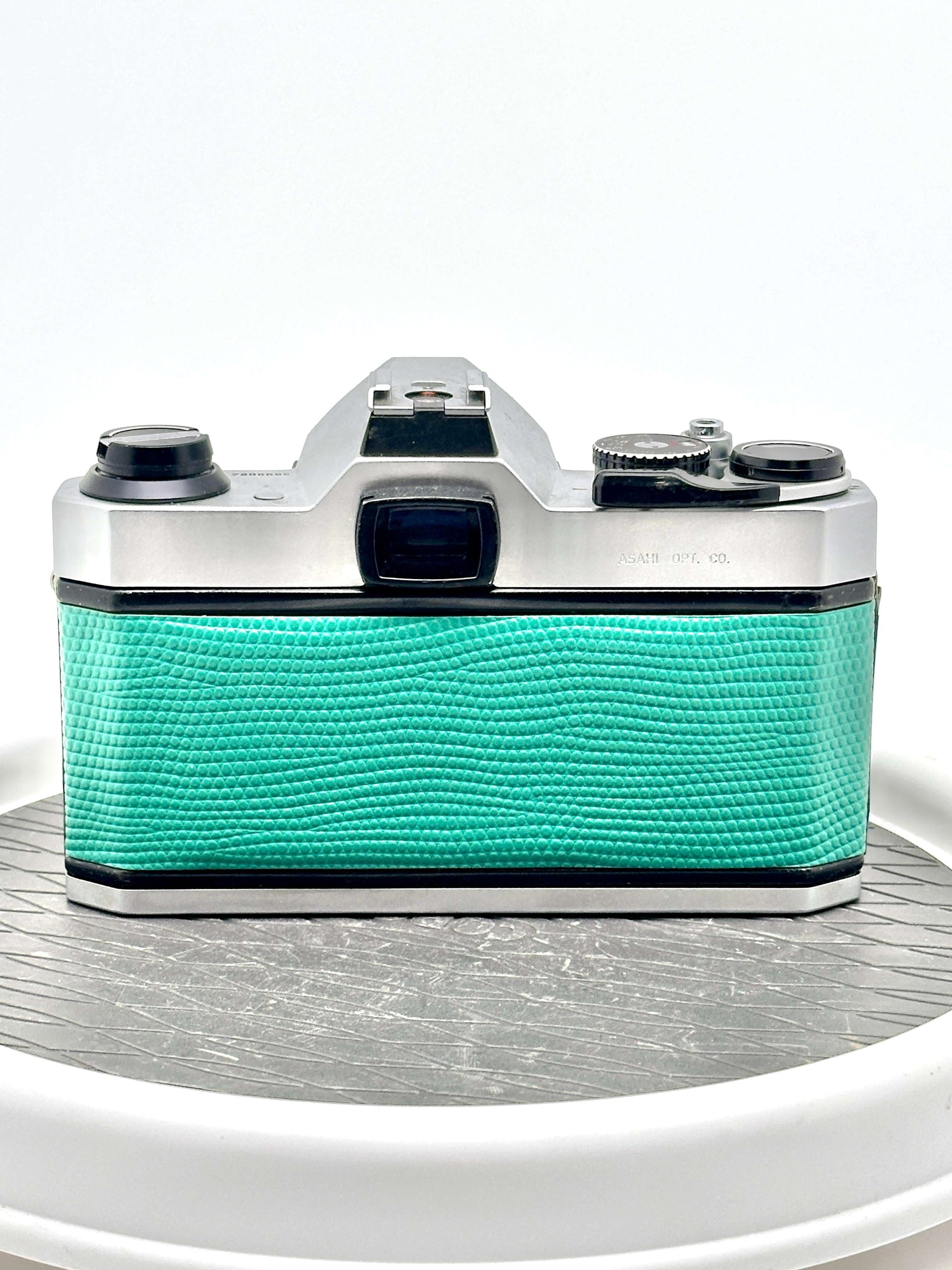 Back view of Japanese Asahi Pentax K1000 used 35mm film camera in teal with textured grip.