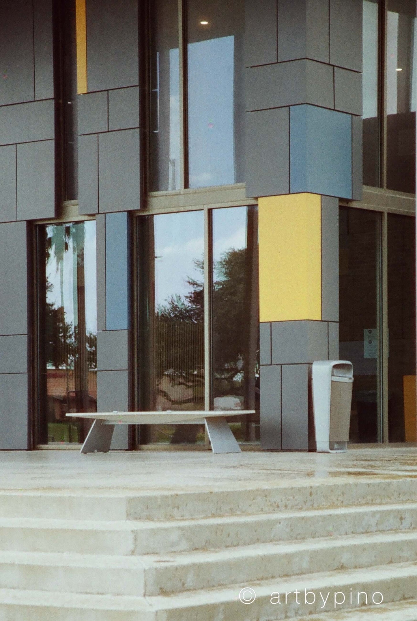 Optik Oldschool OptiColour 200 C41 Film 35mm & 120 displayed near a modern architectural building.