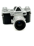 Silver and black praktica fx film camera with a textured leather grip and chrome accents.