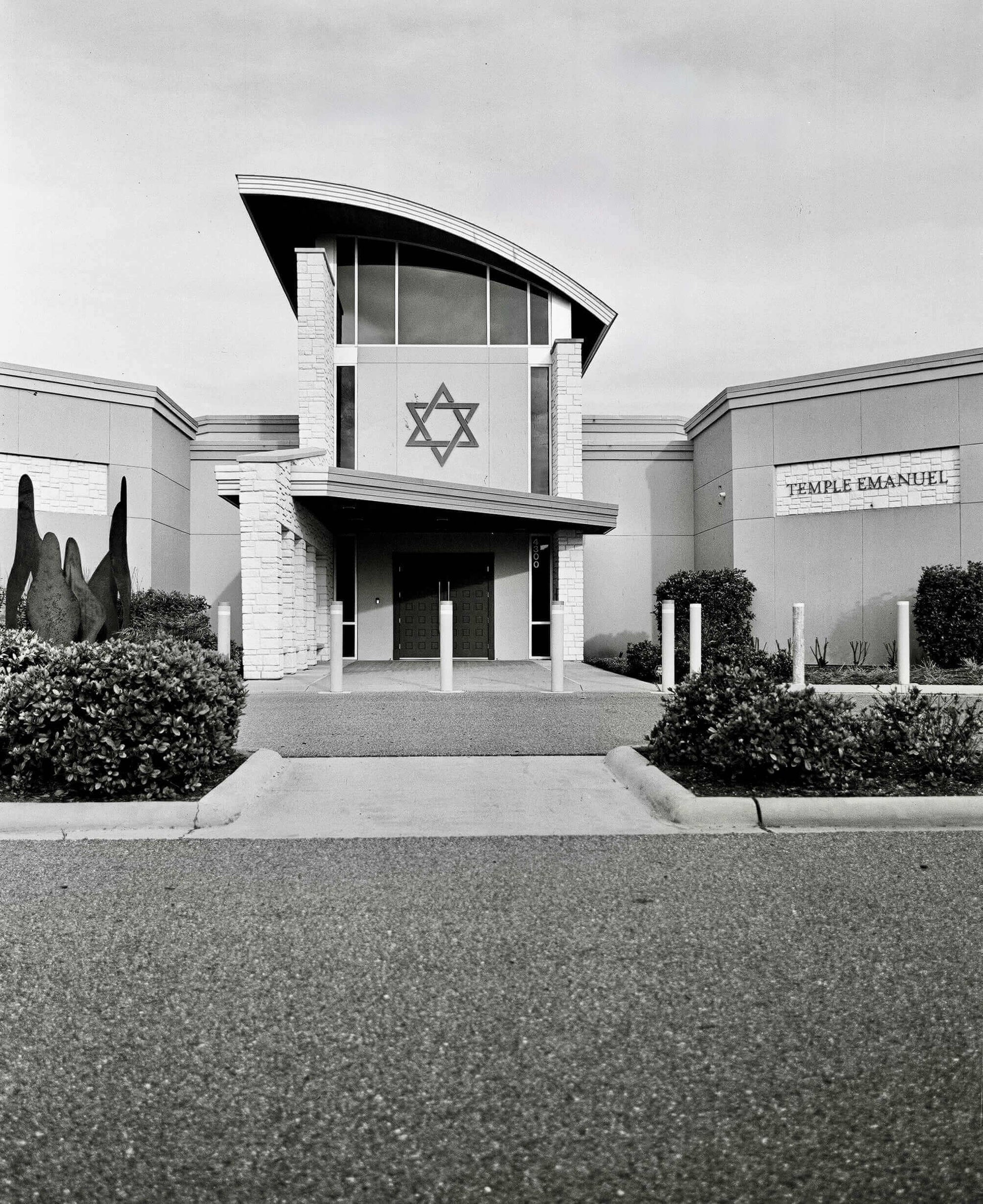 Exterior view of Temple Emanuel featuring a Star of David symbol and modern architectural design.