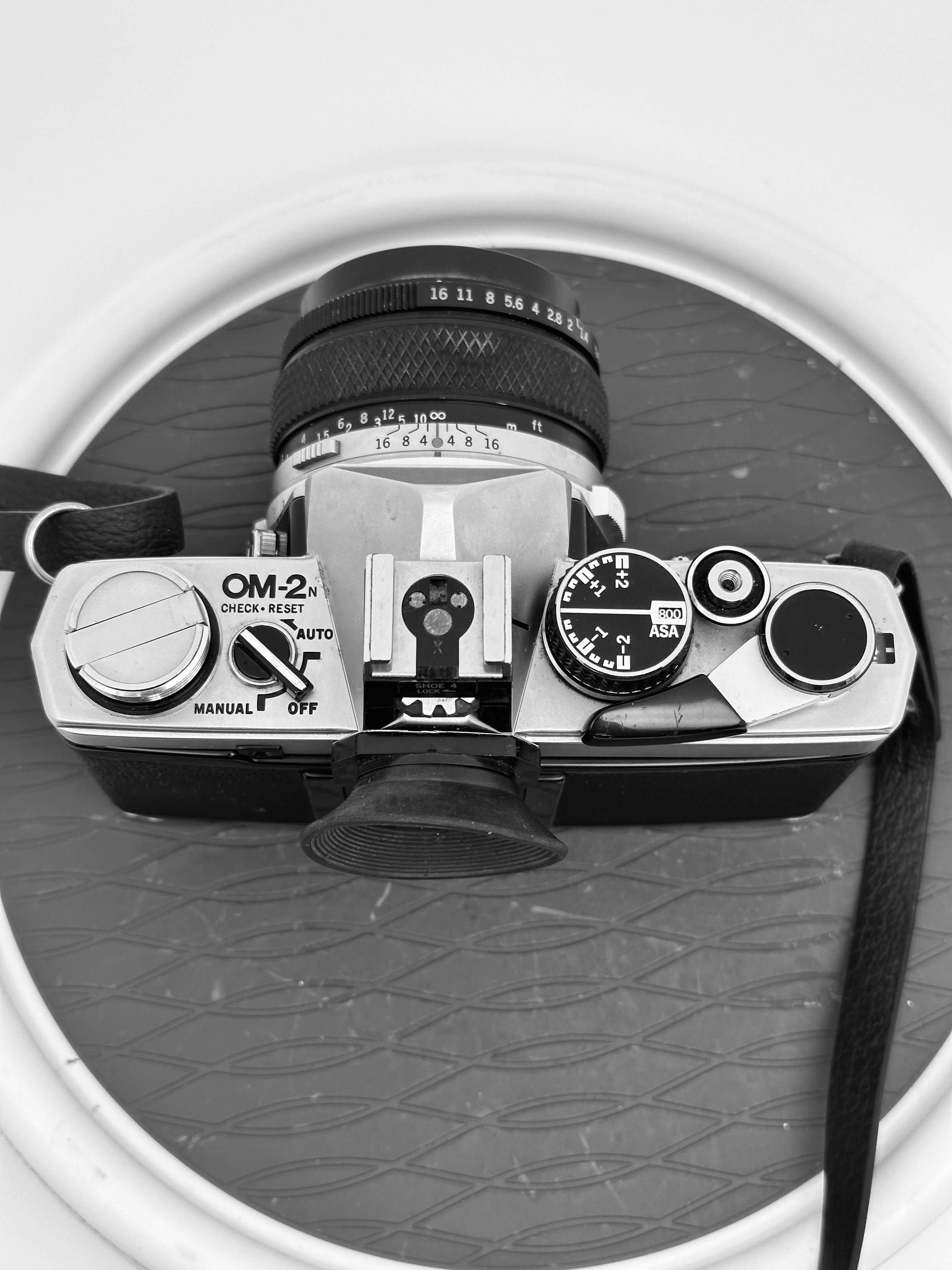 Top view of a vintage Olympus OM-2N 35mm film camera showing controls and Zuiko 50mm f/1.4 lens.