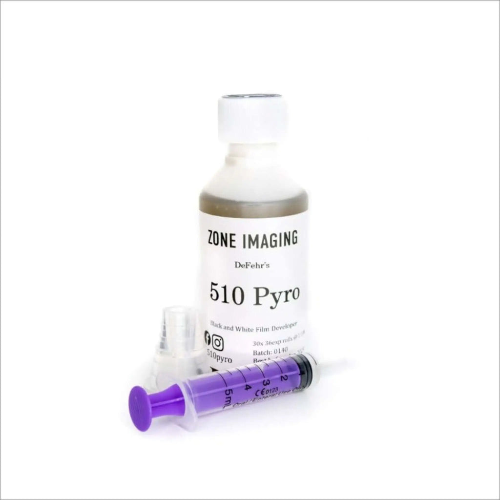 A clear plastic bottle with a white cap, labeled ’zone imaging defehr’s 510 pyro black and white film developer,’ containing a dark brown liquid.