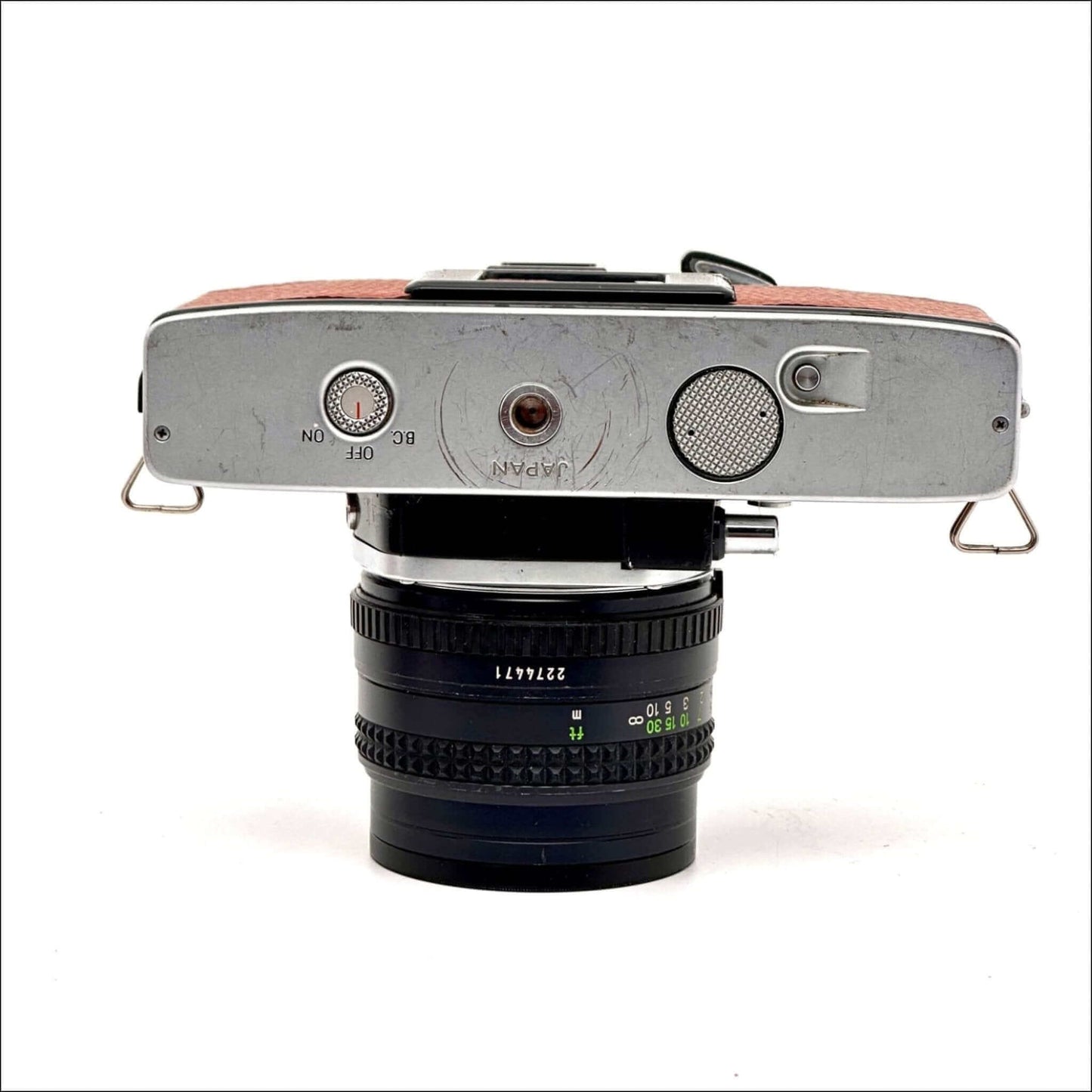 Close-up of a hot pink Canon Canonet QL 17 GIII 35mm rangefinder camera with a lens.